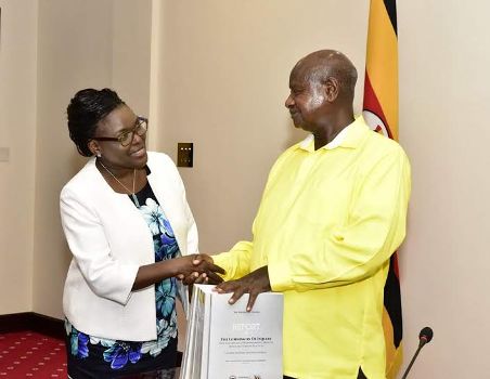 Bamugemereire handing over the probe report to President Yoweri Museveni