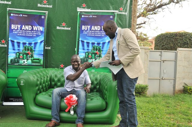 Isaac Lumu receives his sofa set from Nathan Akandwanaho the Heineken National Sales Manager