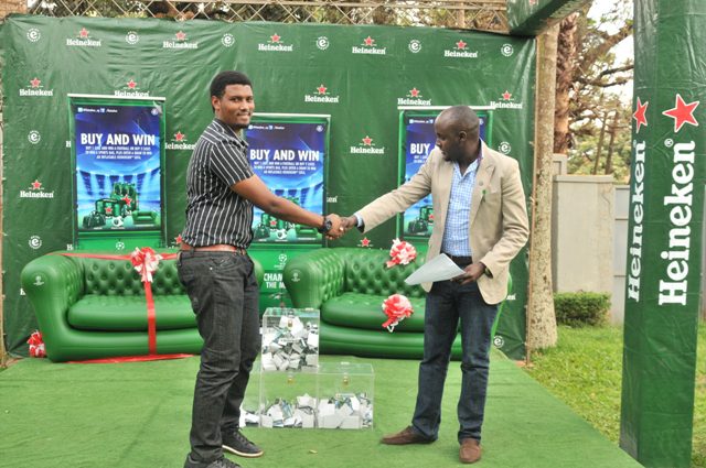 lucky Winner Patrick King receives his Heineken sofa from Nathan Akandwanaho the Heineken National Sales Manager