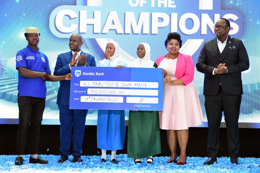 Sarah Kagingo, the Vice Board Chairperson of Private Sector Foundation handing a shield of excellence to Sumaya Girls patron teacher